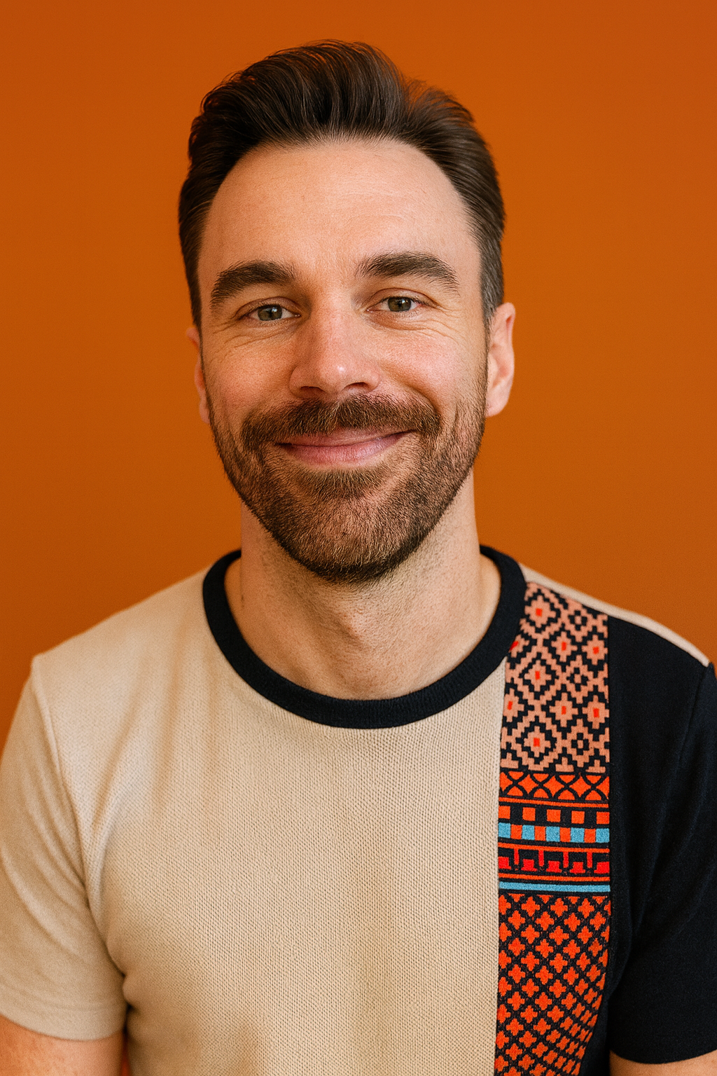 Pete, the Booking Fixer, smiling in front of a warm orange background
